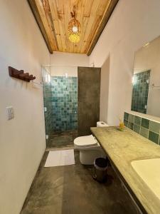a bathroom with a toilet and a sink and a shower at Pousada Buji in Maracajaú +33 photos