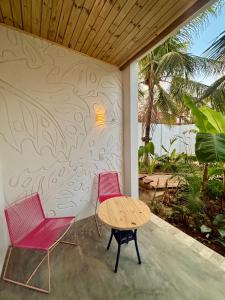 two chairs and a table on a patio at Pousada Buji in Maracajaú