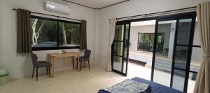 a bedroom with a bed and a table and chairs at Jeab Villa Kohphangan in Ko Phangan