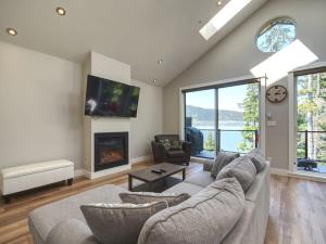 a living room with a couch and a fireplace at Oceanfront & Amazing Views - Pet Friendly - 2bdrm in Port Renfrew
