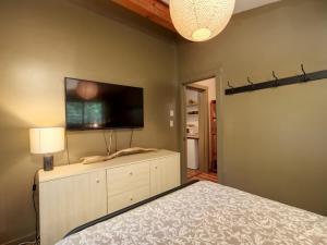 a bedroom with a bed and a flat screen tv at The Rocky Knoll - Garden View - Pet Friendly in Port Renfrew