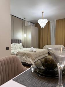 a bedroom with a bed and a table with a plate of food at The Grand CentraL Studio & Люкс Студия в Центре Города Алматы in Almaty