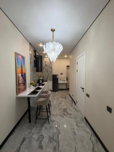 a kitchen with a dining table and a chandelier at The Grand CentraL Studio & Люкс Студия в Центре Города Алматы in Almaty +21 photos