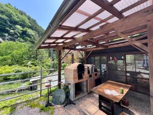 a outdoor kitchen with a wood stove and a table at 神庭-kaniwa- in Chichibu