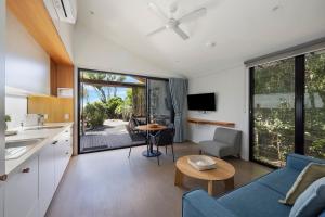 a kitchen and living room with a blue couch at Reflections Byron Bay - Holiday Park in Byron Bay