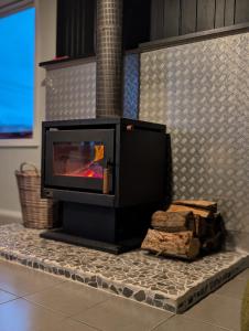 a fireplace in a living room with a tile wall at Salty Devil's Rest - Coastal Wilderness Shack in Arthur River