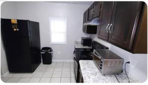 a kitchen with a black refrigerator and a microwave at Cozy Small Private Room 3 on McDaniel Street in Atlanta