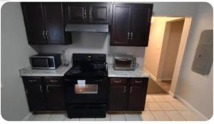 a kitchen with black cabinets and black appliances at Cozy Small Private Room 3 on McDaniel Street in Atlanta