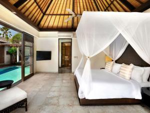 a bedroom with a bed and a pool at Peppers Seminyak in Seminyak