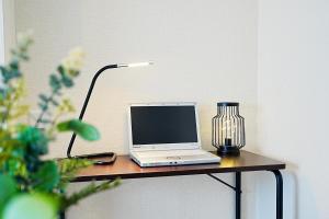 a laptop computer sitting on a table with a lamp at Clair US Tokyo-Disney & Tokyo Sightseeing Base in Tokyo