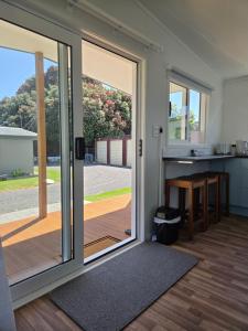 an open sliding glass door in a kitchen with a deck at Te Puru Holiday Park in Thames