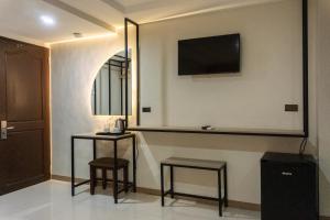 a room with two stools and a tv on the wall at Hotel Rodolfo in Tacloban