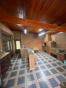 a large room with a stone floor and a brick wall at Sítio encantador com piscina e lazer completo in São Roque