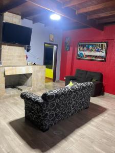 a living room with a couch and a flat screen tv at Sítio encantador com piscina e lazer completo in São Roque