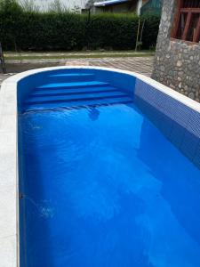 a blue swimming pool with a blue tile border at Cabañas Los Lapachos in Chicoana