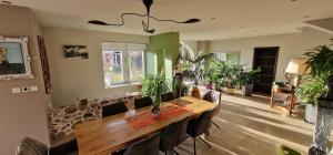 a dining room with a table and some plants at La Ferme des Cherrieres - Piscine Intérieure Chauffée in Rupt-sur-Moselle
