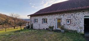 a stone house on a hill with a yard at La Ferme des Cherrieres - Piscine Intérieure Chauffée in Rupt-sur-Moselle