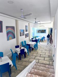 a dining room with tables and blue chairs at Open Sea Hotel Cartagena - Frente al mar in Cartagena de Indias