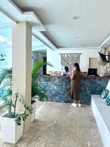 a woman standing at the counter of a restaurant at Open Sea Hotel Cartagena - Frente al mar in Cartagena de Indias