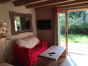 a living room with a red couch and a table at Chalet Mine de rien in Megève