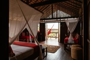 a bedroom with two beds with mosquito netting at Vila Guará in Atins