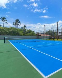 a tennis court with a blue tennis court at Resort beira mar in Porto De Galinhas