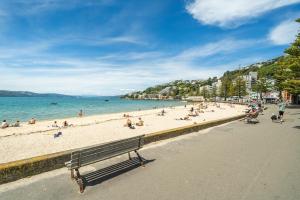 a group of people on a beach near the water at Luxury Beachfront Apartment - Private Upper Suite in Wellington