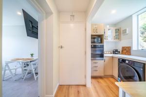 a kitchen with a washer and dryer and a table at Luxury Beachfront Apartment - Private Upper Suite in Wellington