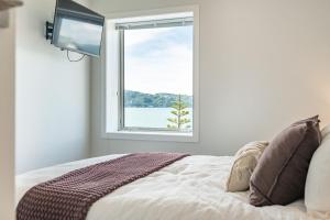 a bedroom with a bed and a window at Luxury Beachfront Apartment - Private Upper Suite in Wellington