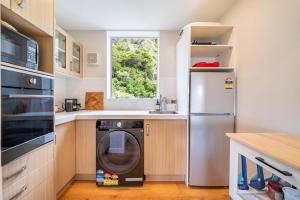 a kitchen with a washing machine and a window at Luxury Beachfront Apartment - Private Upper Suite in Wellington +8 photos