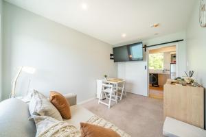 a living room with a couch and a kitchen at Luxury Beachfront Apartment - Private Upper Suite in Wellington