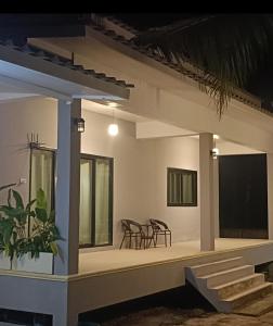 a house with a porch with chairs and a table at Jeab Villa Kohphangan in Ko Phangan