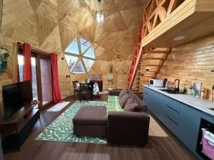 a living room with a couch and a kitchen in a log cabin at Domo loft puacura - tinaja disponible in Castro
