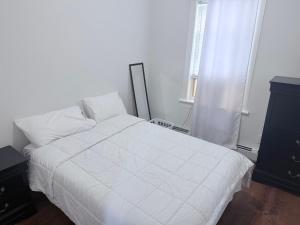 a bedroom with a white bed and a window at Cozy single room in Fall River