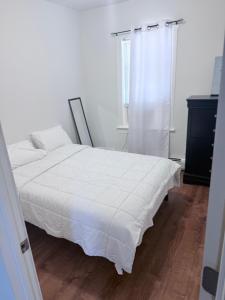 a bedroom with a white bed and a window at Cozy single room in Fall River
