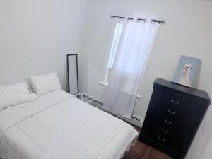 a bedroom with a bed and a dresser and a window at Cozy single room in Fall River