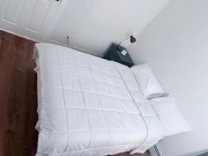 a bed with white pillows in a room at Cozy single room in Fall River