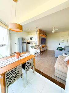 a kitchen and living room with a table and chairs at Encanto da Praia LUXO Ap 2 qts Pe na Areia Camboinhas in Niterói