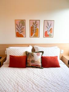 a white bed with four pillows in a bedroom at Encanto da Praia LUXO Ap 2 qts Pe na Areia Camboinhas in Niterói +86 photos