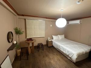 ein kleines Schlafzimmer mit einem Bett und einem Tisch in der Unterkunft 부일파크 in Suwon