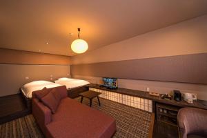 a hotel room with a bed and a couch at SEKIYA RESORT Terrace Midoubaru in Beppu