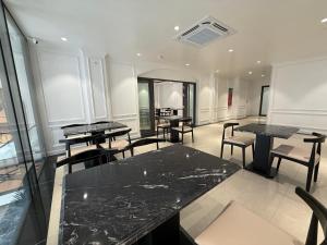 a room with tables and chairs in a building at The Nova Hotel & Apartment in Hai Phong