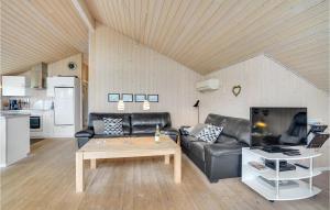 a living room with a leather couch and a coffee table at Amazing Home In Tarm With Sauna in Tarm