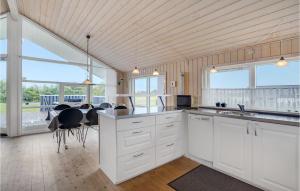 a kitchen with white cabinets and a table with chairs at Amazing Home In Tarm With Sauna in Tarm