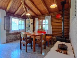 a dining room with a wooden table and chairs at Cabaña de troncos en Nono, Córdoba in Nono