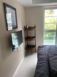 a bedroom with a bed and a tv on the wall at Cristians lägenhet in Kata Beach