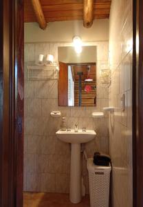 a bathroom with a sink and a mirror at Cabaña de troncos en Nono, Córdoba in Nono +11 photos