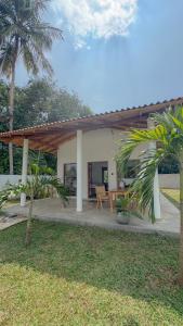 a house with a patio with a table and palm trees at Villa Palm in Rekawa