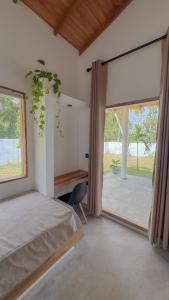a bedroom with a bed and a large window at Villa Palm in Rekawa