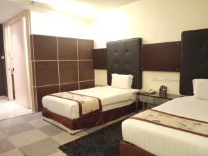 a hotel room with two beds and a telephone at Shervinton Executive Boutique Hotel in Tawau +94 photos